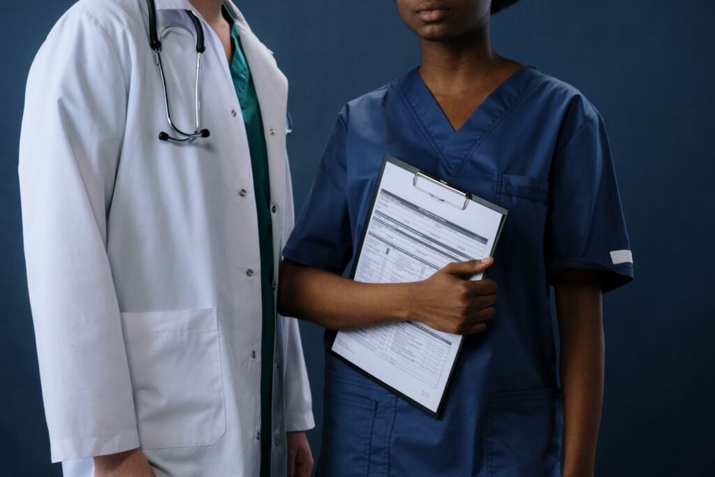 Two healthcare professionals in scrubs with a clipboard, illustrative stock photo